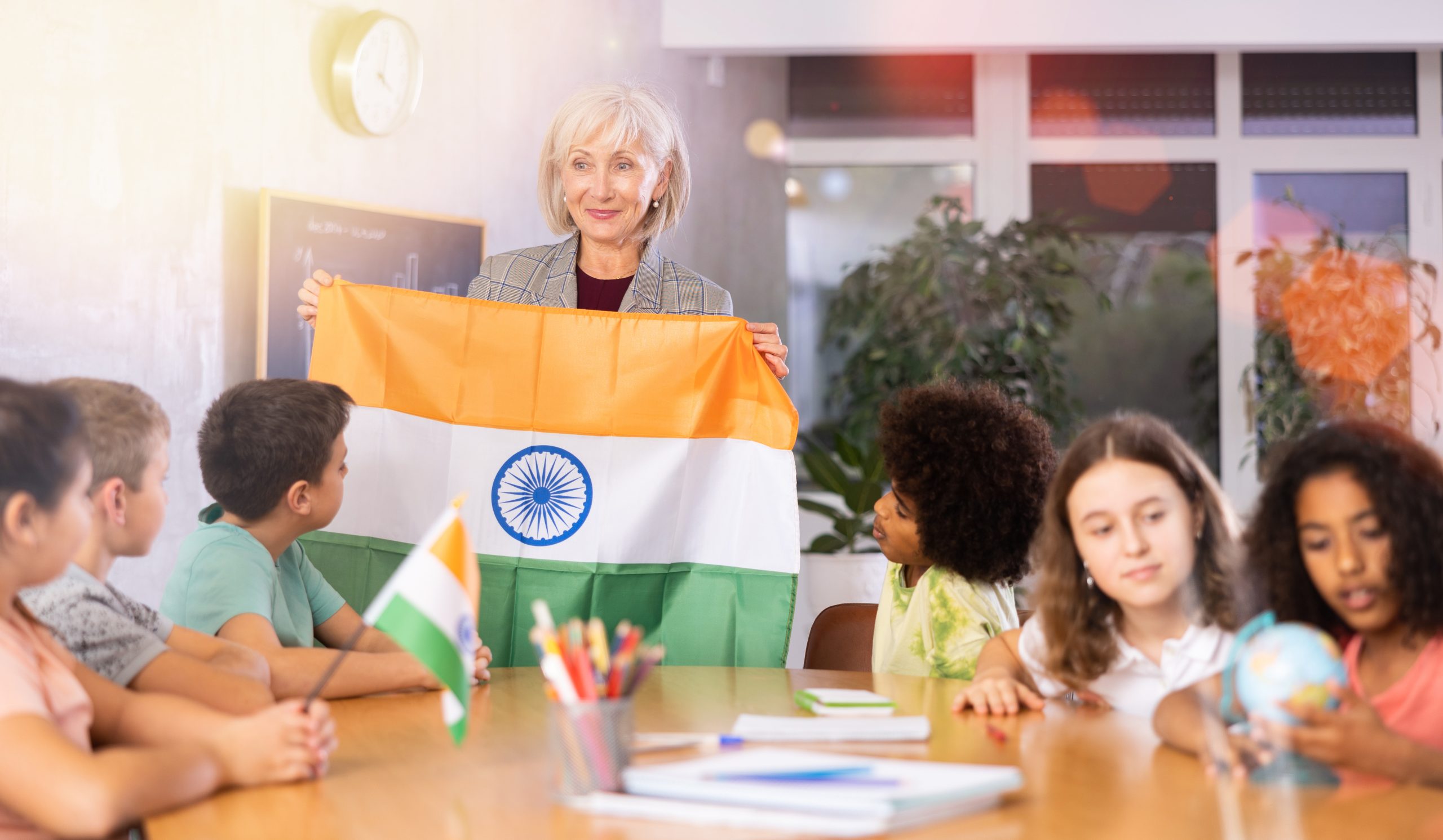 A progressive Indian classroom with a foreign teacher teaching Indian students geography